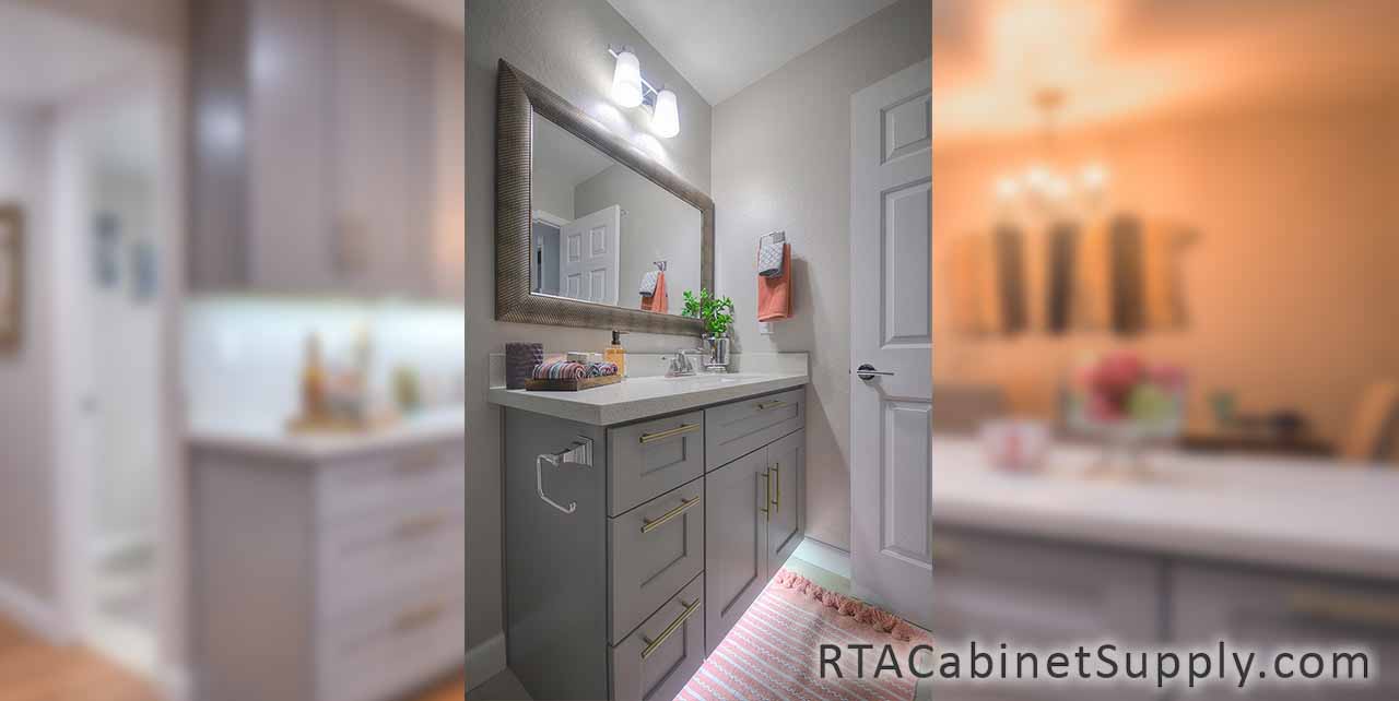 Classic Grey Shaker bathroom angle view with lighting, a mirror and base cabinets.