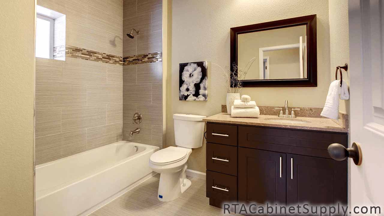 Sienna Shaker bathroom angle view with a bathtub, a mirror, a sink and base cabinets.