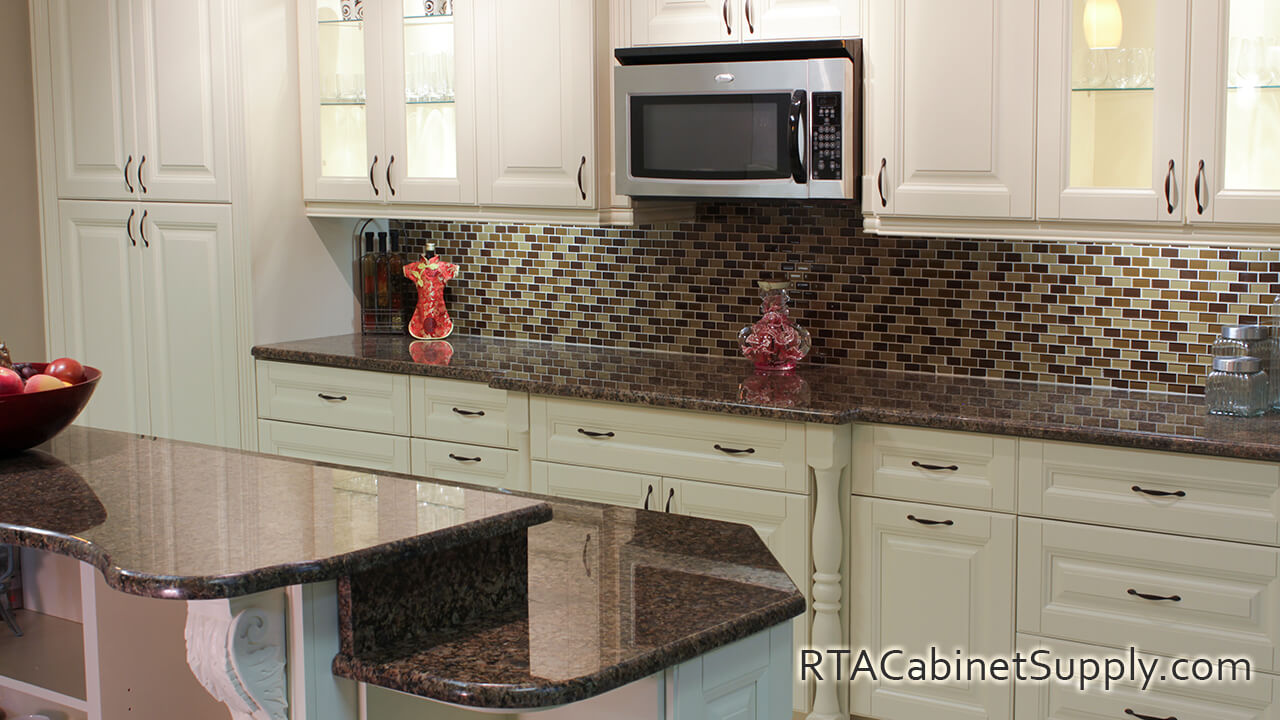 Holmdel Cream kitchen angle view with a pantry cabinet, an island, wall and base cabinets.
