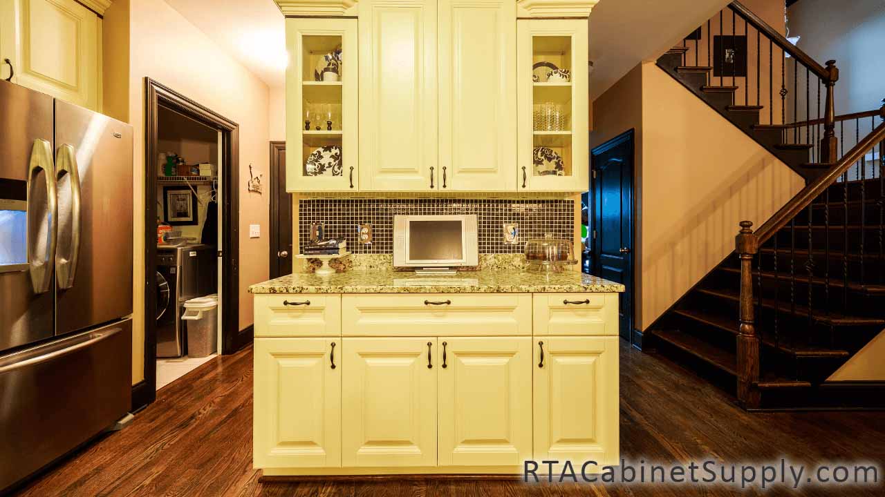 Oxfrord Cream kitchen full view with glass door cabinets, a countertop, wall and base cabinets.