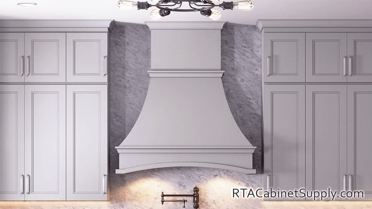 Preston Grey kitchen close up view with a range hood cover and wall cabinets.