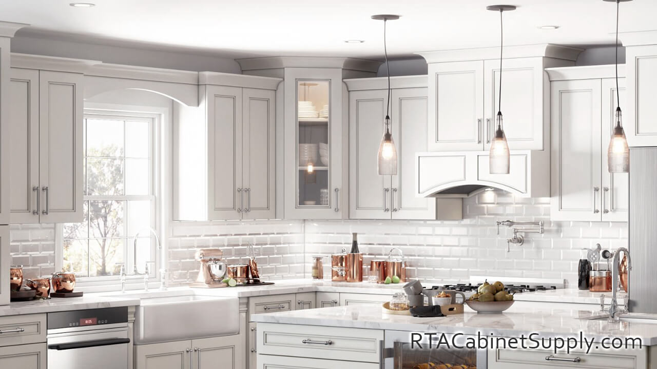 Preston White kitchen close up view with an island, lighting, a range hood cover, a glass door cabinet, wall and base cabinets.