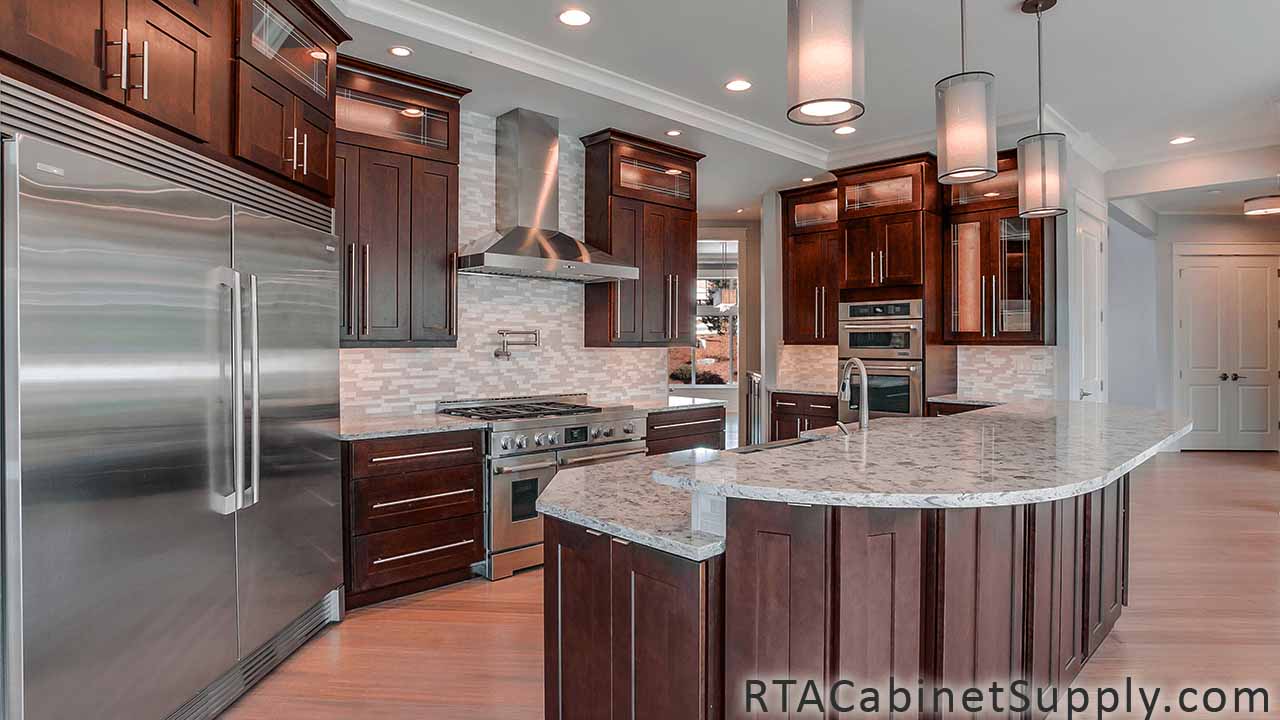 Sienna Shaker kitchen full angle view with lighting, a range hood, an oven, a countertop, an island, wall and base cabinets.