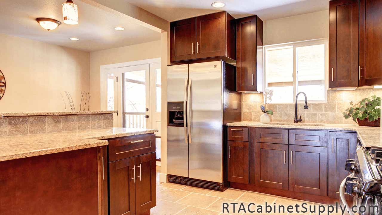 Sienna Shaker kitchen angle view with a fridge, a countertop, wall and base cabinets.