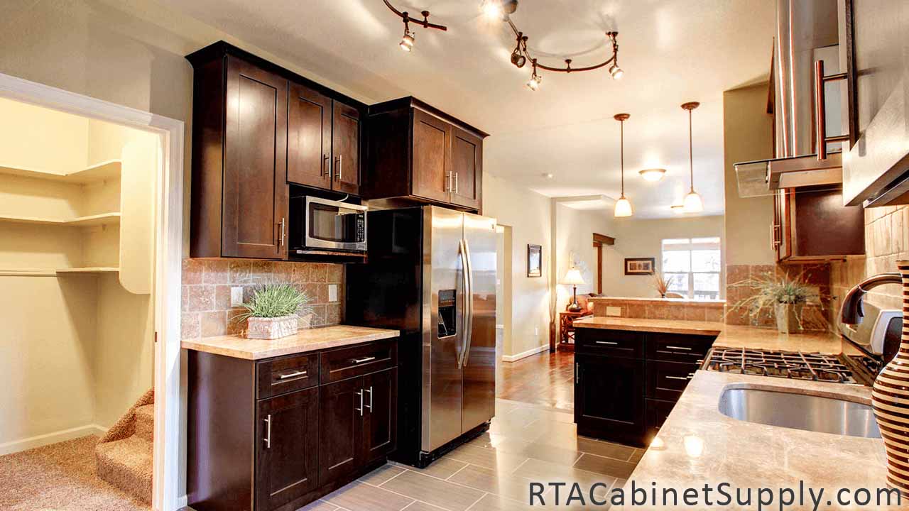 Sienna Shaker kitchen full angle view with a fridge, a range hood, lighting, an oven, a countertop, wall and base cabinets.