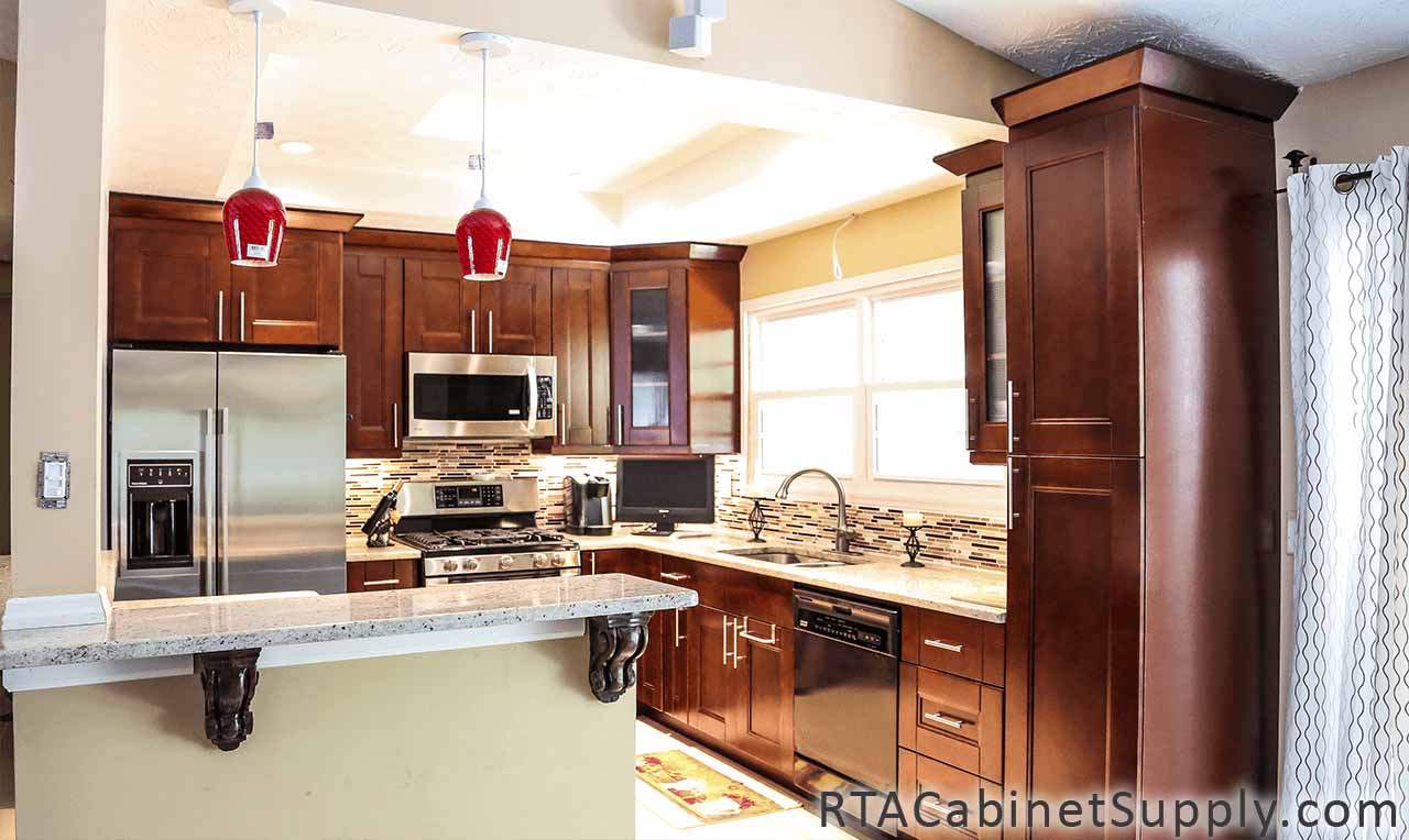 Walnut Shaker kitchen full angle view with a fridge, glass door cabinets, a countertop, lighting, wall and base cabinets.