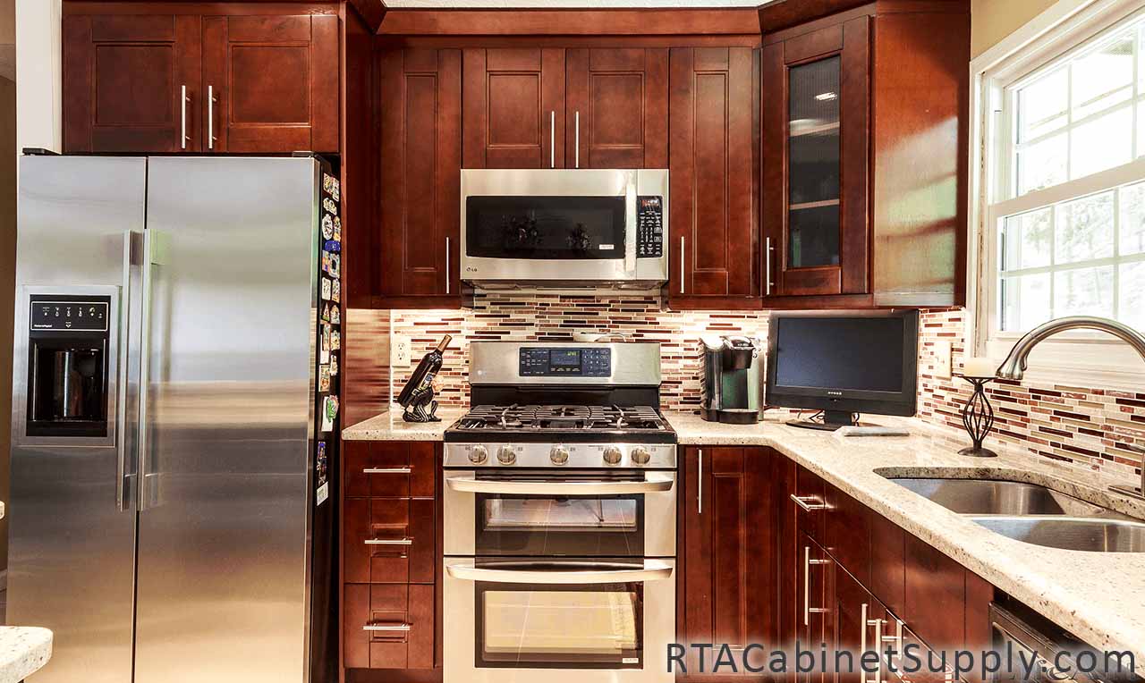 Walnut Shaker kitchen full view with a fridge, a glass door cabinet, a countertop, wall and base cabinets.