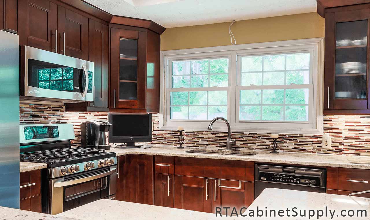 Walnut Shaker kitchen angle view with glass door cabinets, a countertop, an oven, wall and base cabinets.