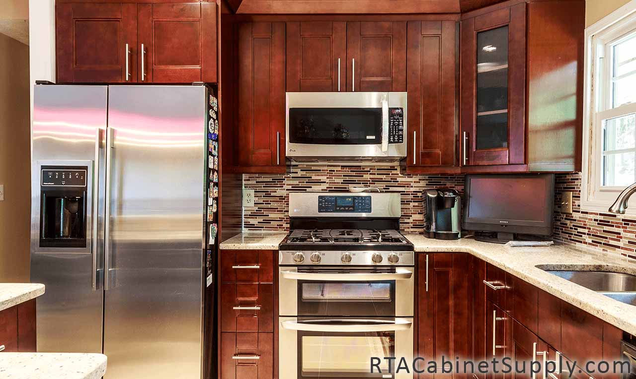 Walnut Shaker kitchen close up angle view with an oven, a glass door cabinet, a countertop, wall and base cabinets.