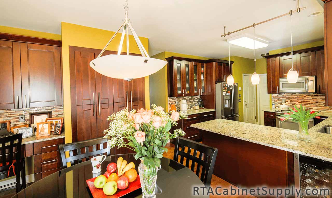 Walnut Shaker kitchen angle view with glass door cabinets, base and wall cabinets, pantry cabinets.
