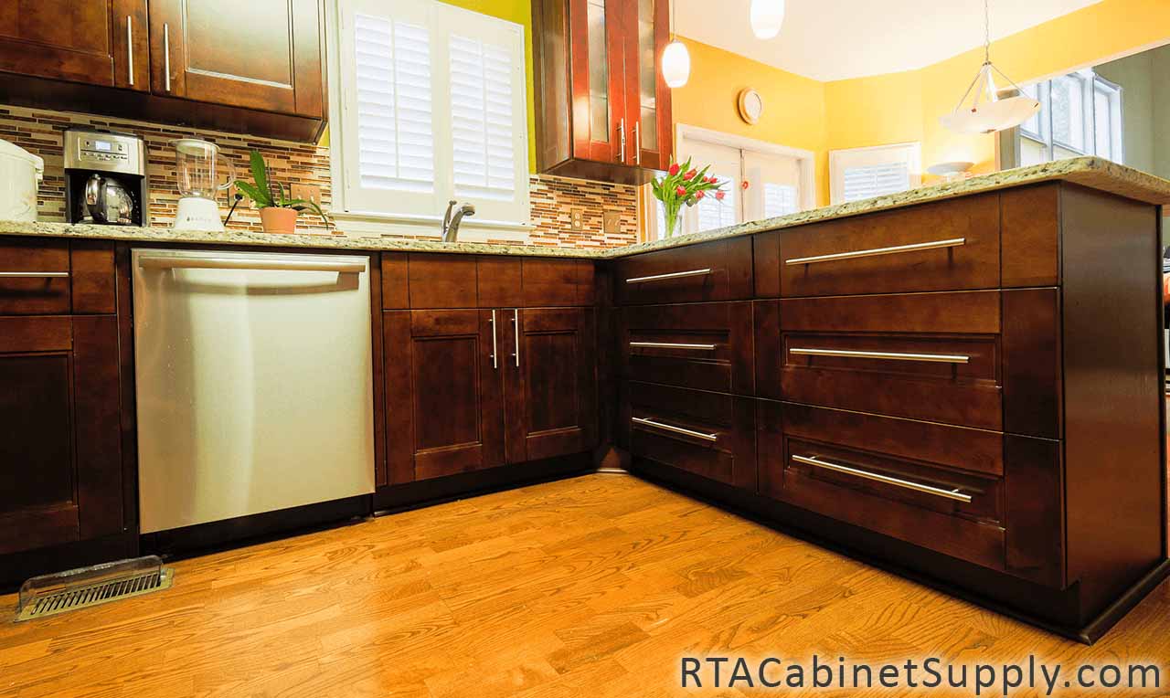 Walnut Shaker kitchen angle view with a glass door cabinet, wall and base cabinets.