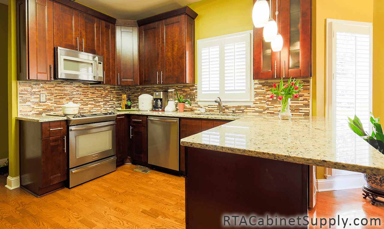 Walnut Shaker kitchen angle view with an oven, a glass door cabinet, a countertop, wall and base cabinets.