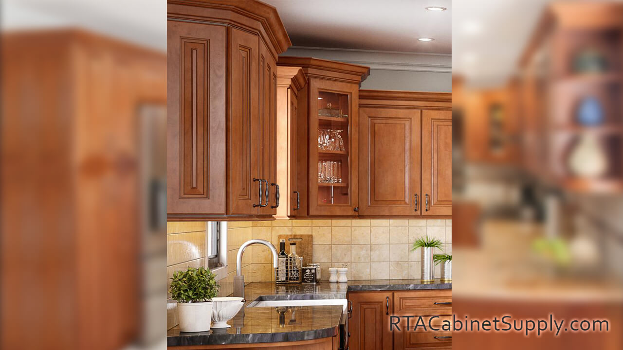 Windsor Cinnamon Glaze kitchen close up view with a glass door cabinet, a countertop, and wall cabinets.