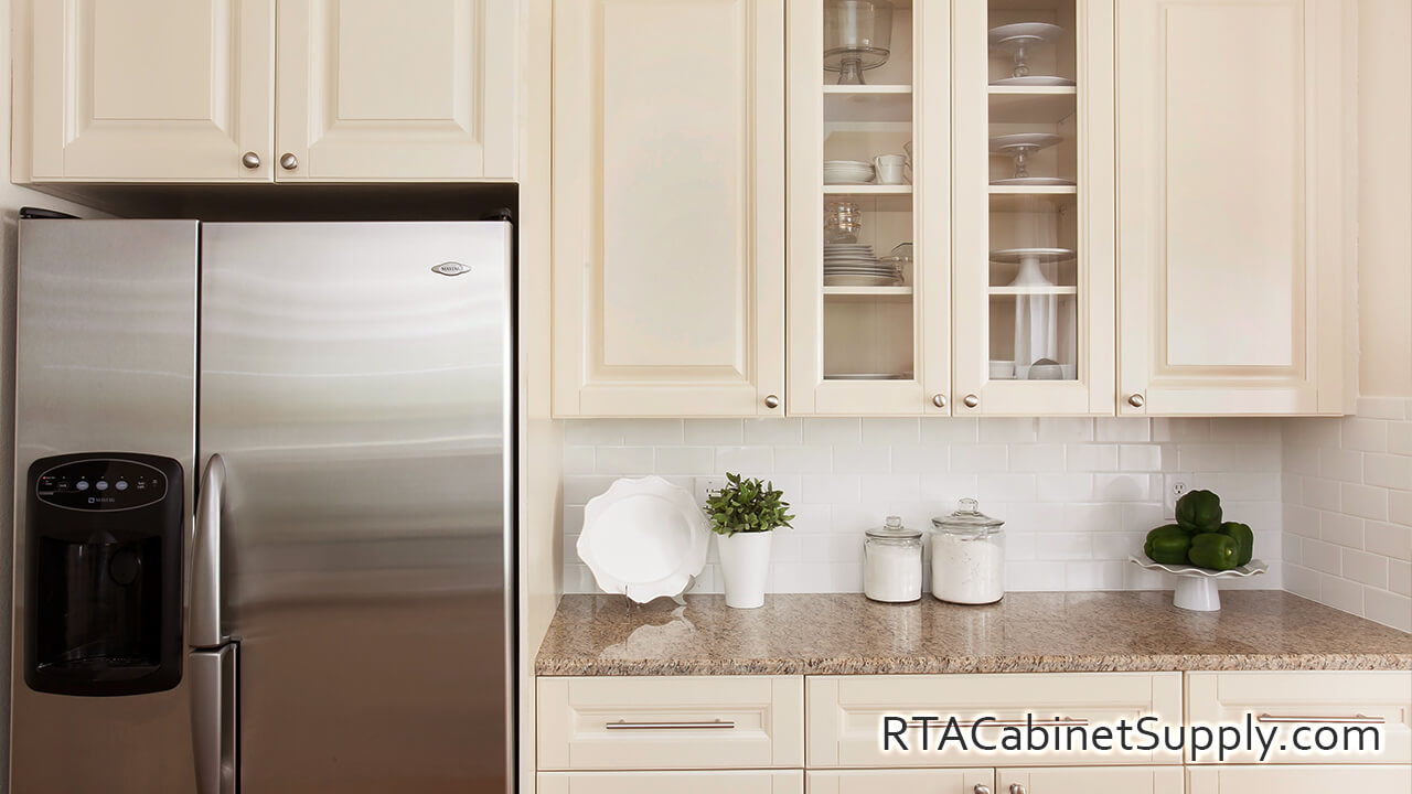 Holmdel Cream kitchen close up view with a fridge, glass door cabinet, wall and base cabinets.