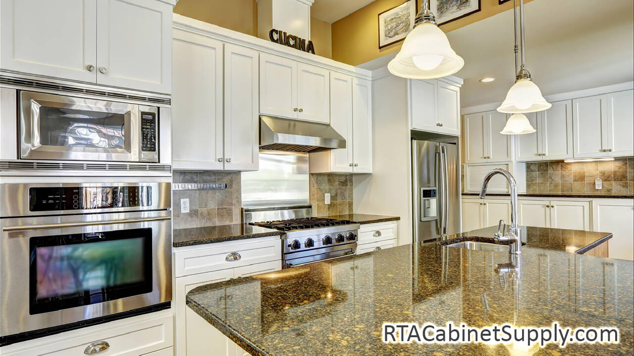 Camden Dove Shaker kitchen angle angle view with an island, wall and base cabinets, lighting and a fridge.