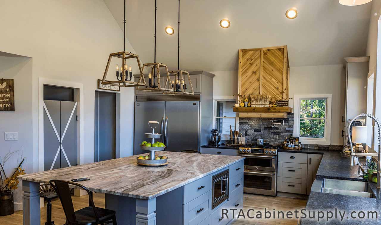 Anchester Grey kitchen close up angle view with an island, lighting, a range hood and base cabinets.