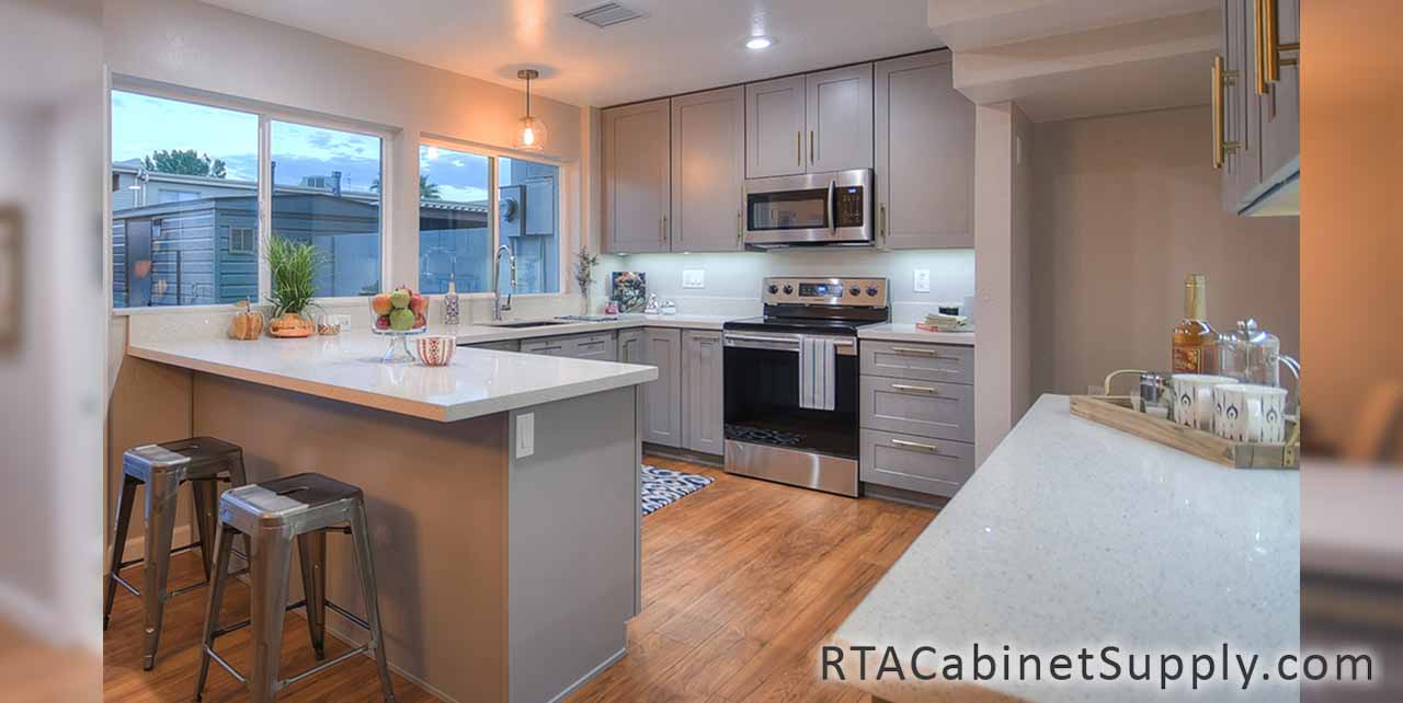 Classic Grey Shaker kitchen full angle view with a countertop, wall and base cabinets, lighting and an oven.