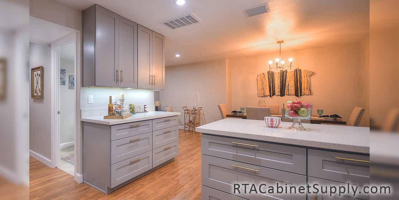 Classic Grey Shaker kitchen angle view with an island, lighting, wall and base cabinets.