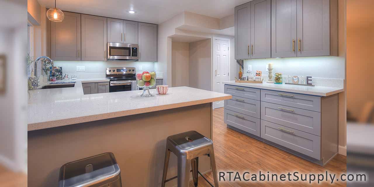 Classic Grey Shaker kitchen close up view with an island, lighting, wall and base cabinets.