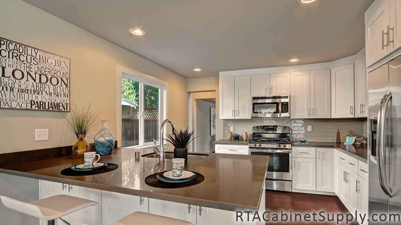 Classic White Shaker kitchen full angle view with an island, wall and base cabinets, lighting and open shelving.