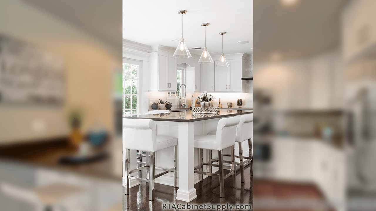 Classic White Shaker kitchen close up view with an island, lighting and chairs.