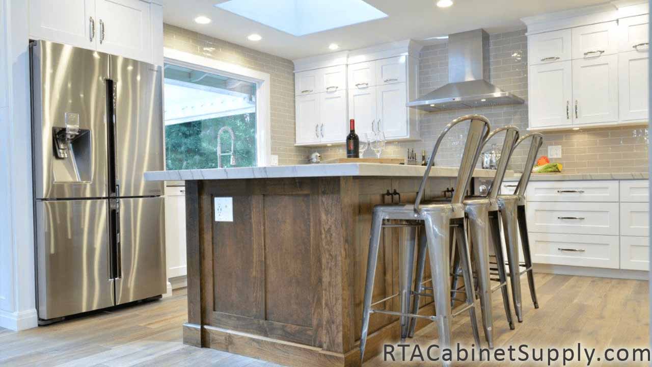 Classic White Shaker kitchen close up angle view with wall and base cabinets, a fridge and an island.