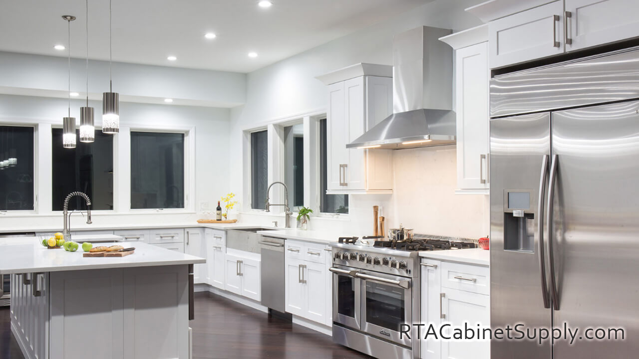 Classic White Shaker kitchen angle view with an island, an oven, wall and base cabinets.