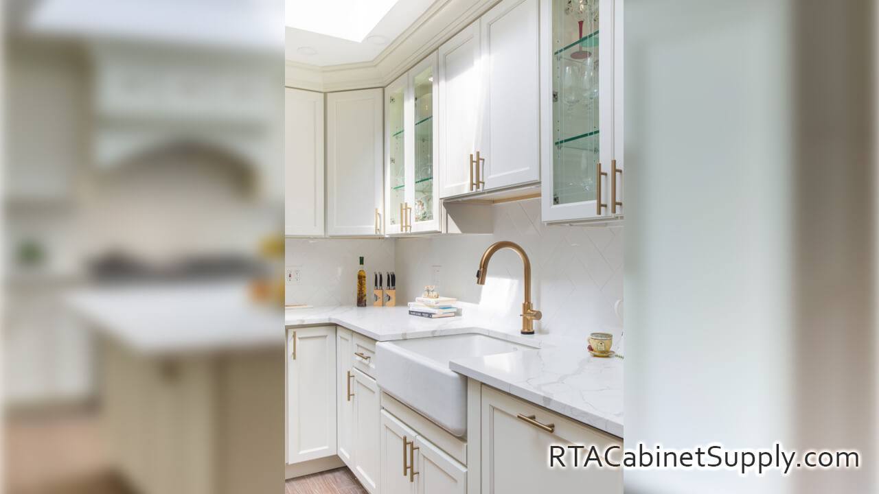 Hanover Dove kitchen angle view with a countertop, glass door cabinets, a farmhouse sink cabinet, wall and base cabinets.