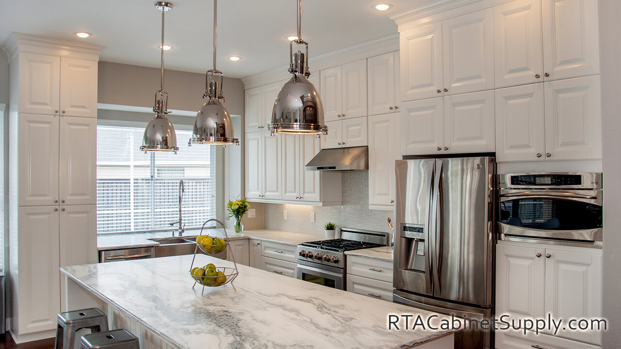 Essex White kitchen angle view with an island, lighting, a fridge, a pantry, wall and base cabinets.