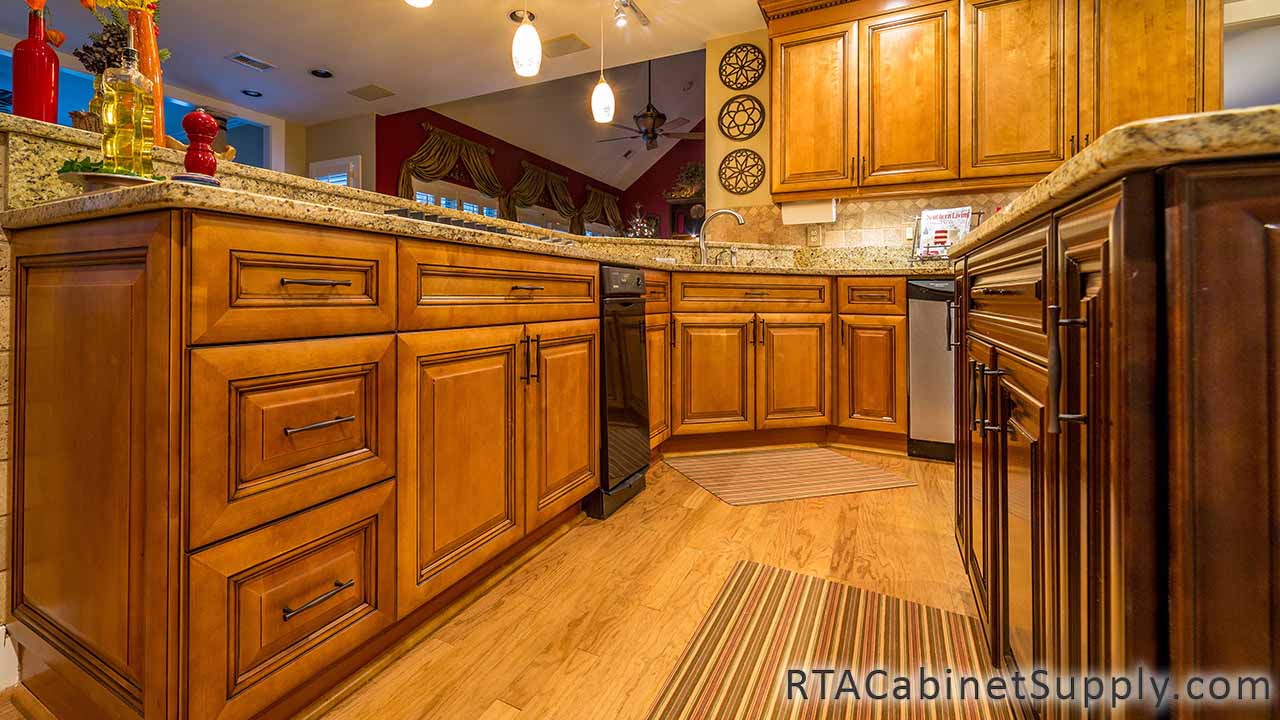 Kingston Maple kitchen close up view with an island, lighting, wall and base cabinets.