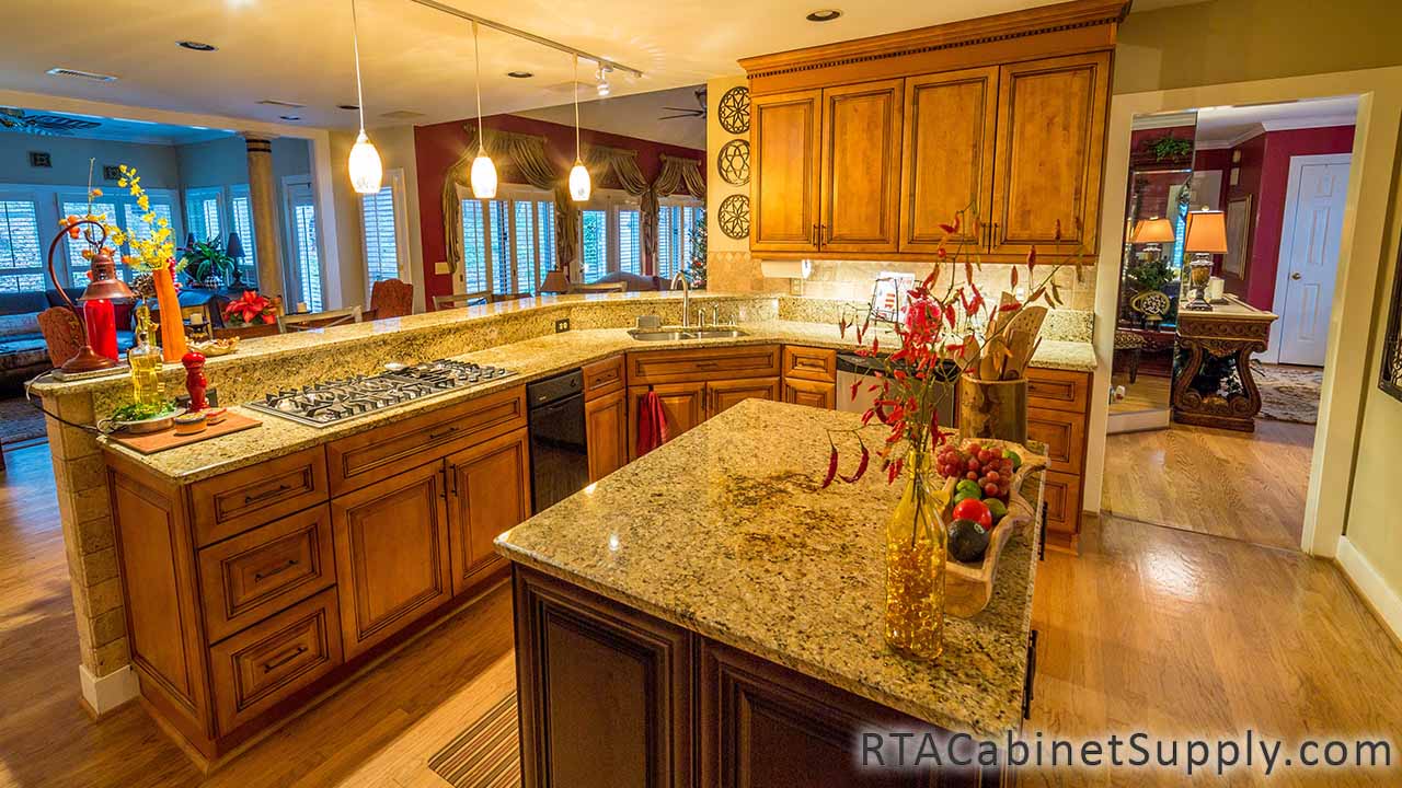 Kingston Maple kitchen angle view with an island, lighting, wall and base cabinets.