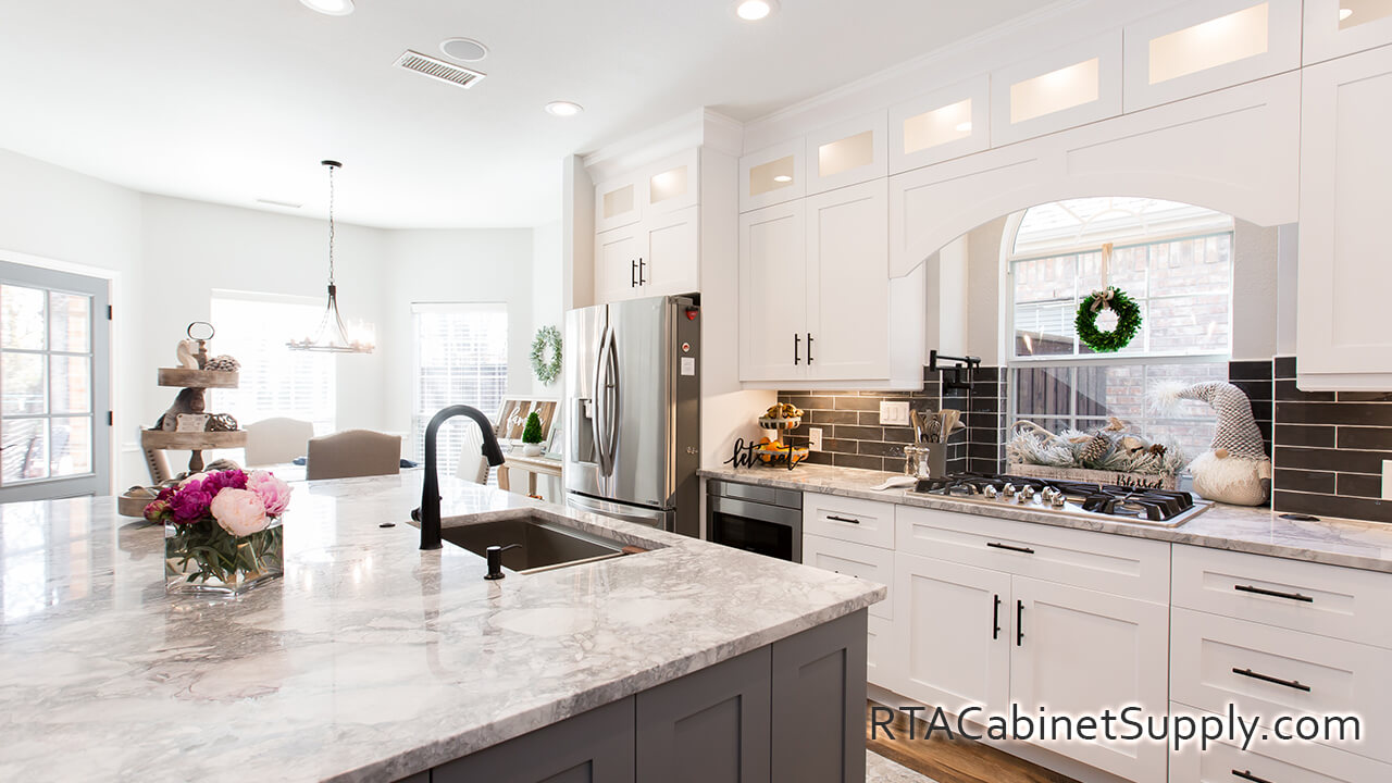 Madison White Shaker kitchen angle view with wall and base cabinets, glass door cabinets, a fridge, lighting and an oven.