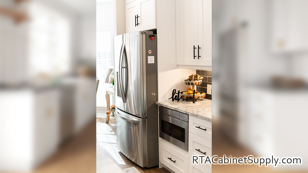 Madison White Shaker kitchen close up view with a fridge, wall and base cabinets.