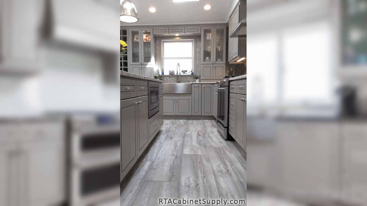 Modern Grey kitchen close up view with glass door cabinets, a farmhouse sink cabinet, wall and base cabinets.
