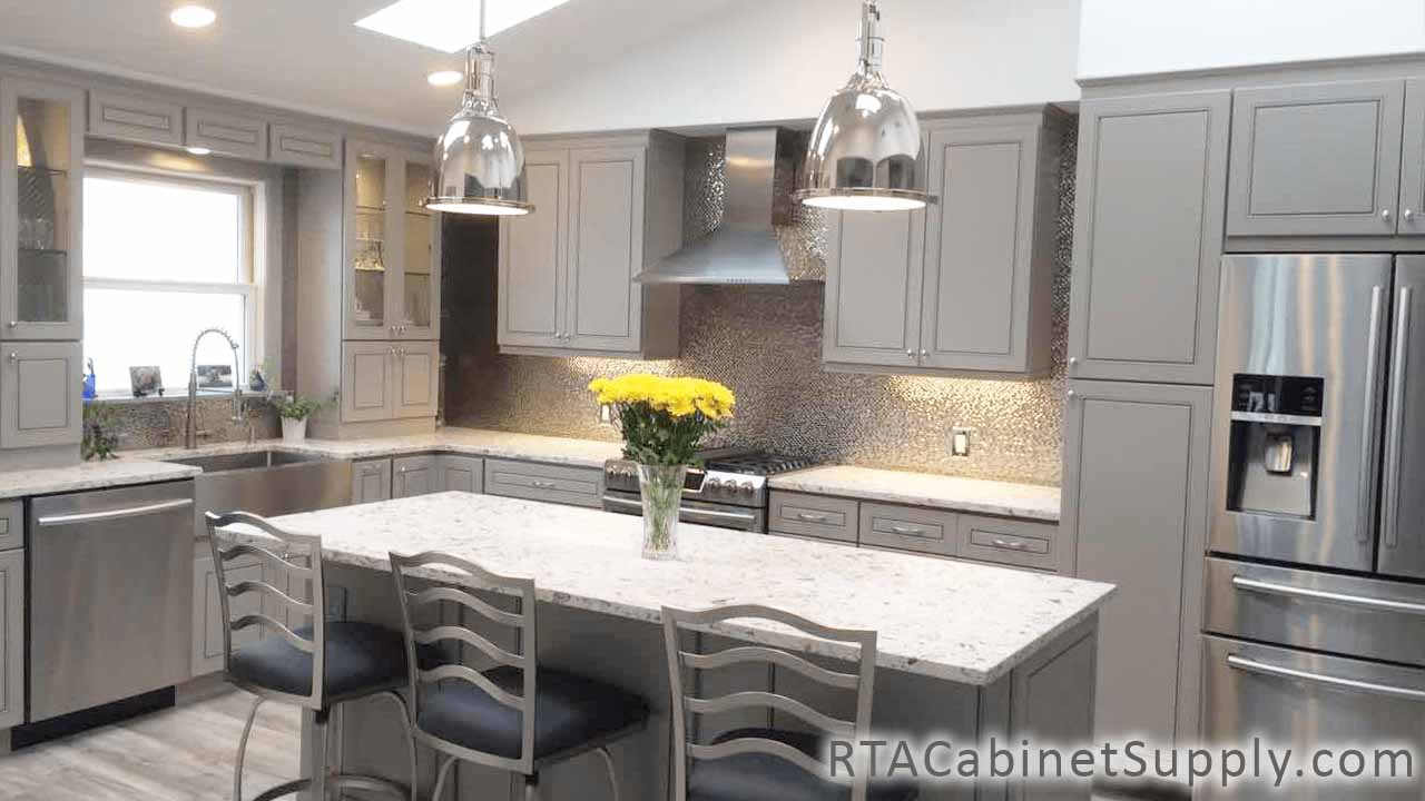 Modern Grey kitchen angle view with lighting, an island, chairs, wall and base cabinets.
