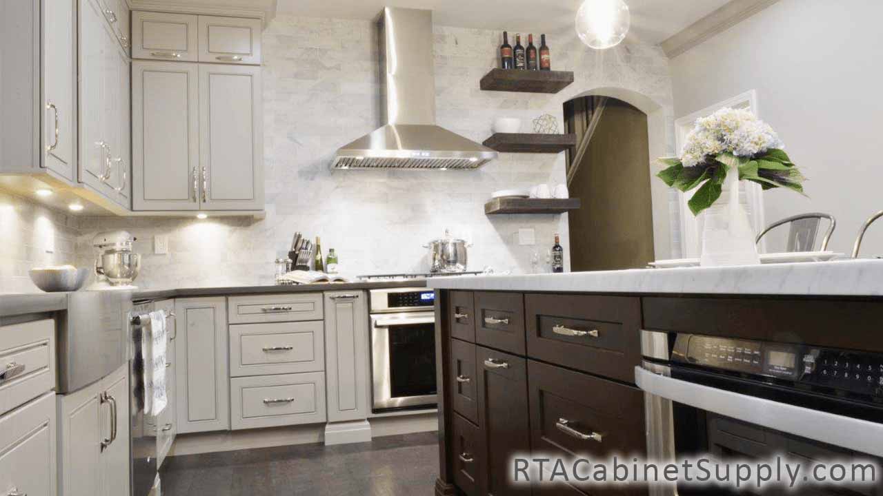 Modern Grey kitchen full view with an oven, a range hood, a farmhouse sink cabinet, an island, wall and base cabinets.