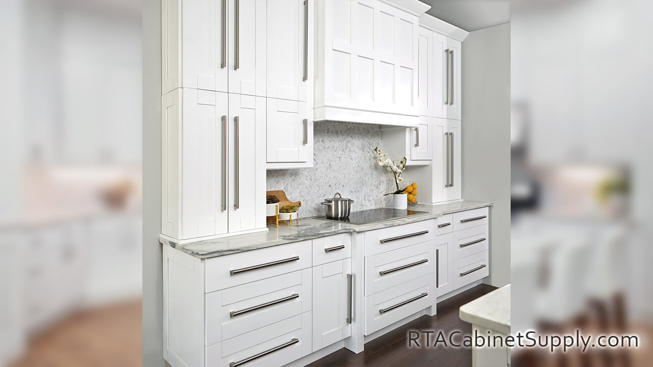 Modern White Shaker kitchen angle view with a countertop, wall and base cabinets.